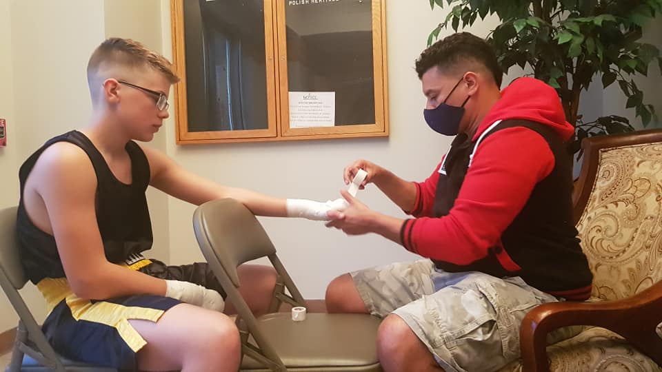 Head Coach, Willy Martinez, wrapping fighters hands for Dreyden Phillips.